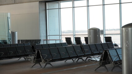 Empty airport terminal lounge. Empty airport seating - typical black chairs in boarding waiting