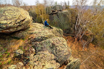 mature male Tourist resting on a rock on the irendyk ridge in the southern Urals in early spring
