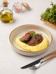 Portion of russian beef cutlets with mashed potato and herbs