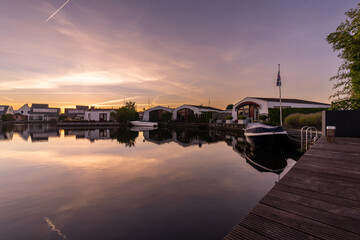 Ferienh&auml;user und Boote bei D&auml;mmerung am Kanal in Lemmer Holland
