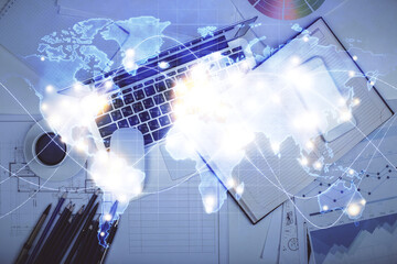 Business theme hologram drawings over computer on the desktop background. Top view. Multi exposure. Concept of international connections.