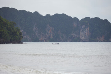 Majestic island with longtail boat on the sea