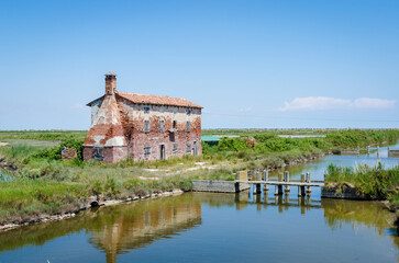 Caratteristico paesaggio della laguna nord di Venezia verso Lio Piccolo con una casa diroccata in una giornata primaverile di sole