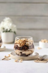 Dessert in glasses, chocolate biscuit with peanut cream, banana and nuts
