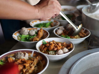 Selective focus Mie ayam, mi ayam or bakmi ayam indonesian for chicken bakmi, literally chicken noodles, is a common Indonesian dish of seasoned yellow wheat noodles topped with diced chicken meat.