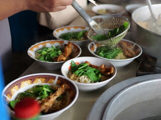 Selective focus Mie ayam, mi ayam or bakmi ayam indonesian for chicken bakmi, literally chicken noodles, is a common Indonesian dish of seasoned yellow wheat noodles topped with diced chicken meat.