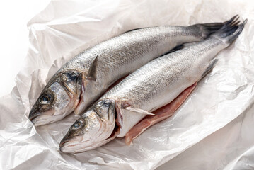 Sea bass fish. Two peeled raw sea bass on wrapping paper