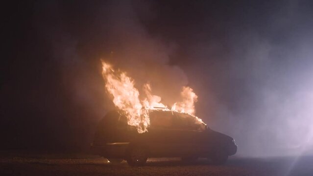 Burning car slow motion. Automobile on fire. Transport explosion. Theme of criminal revenge and set fire to someone else car.