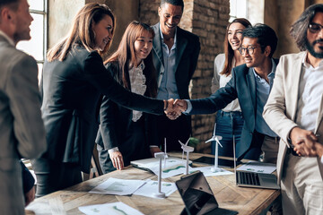 diverse multiethnic businesspeople shaking hands at meeting table - company agreement - project...