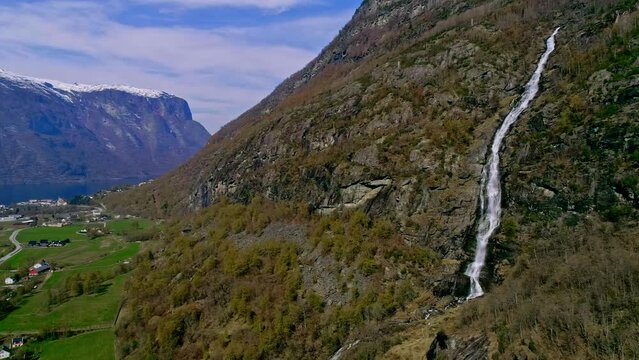 Aerial drone forward moving shot of majestic mountains with Kjelfossen waterfall near Gudvangen Village, Aurland Municipality, Vestland County, Norway at daytime.