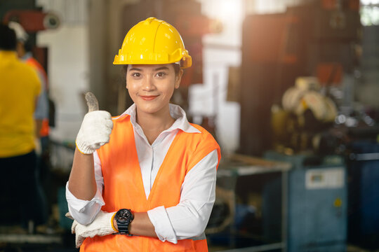 portrait teen working woman in heavy industry lathe machine steel tool factory happy smile thumbs up