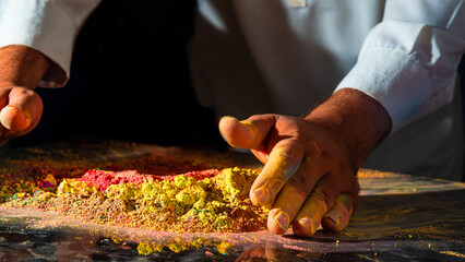 Artist working raw handed with colors powder