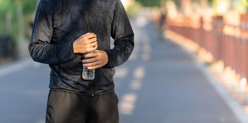 Close up of sports man holding water bottle.
