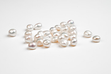 Natural freshwater round pearl beads on white background. Top view