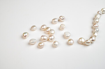 Natural freshwater round pearl beads on white background. Top view