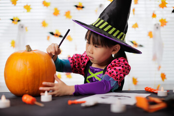 young girl was doing pumpkin carving  for halloween party at home