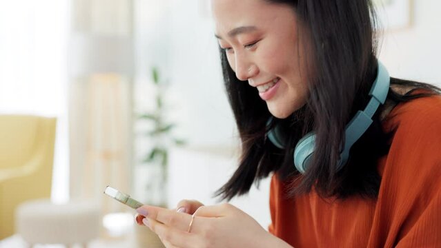 Smartphone, typing and happy woman social networking online, using phone mobile app or chat in her apartment. Asian gen z girl on cellphone communication, social media update or music subscription