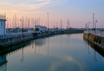 Senigallia, Italy: view of the harbor on the sunset over the yachts and boats. Urban view. City...