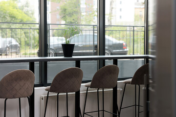 Table and bar stools near window in hostel dining room