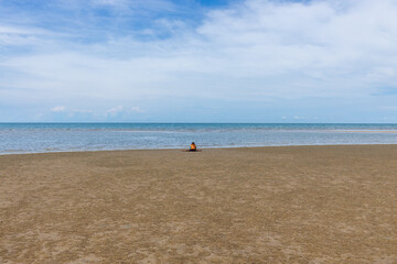 Jeune fille jouant assise sur la plage