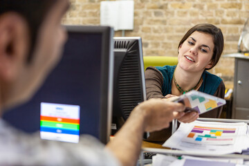 The Media Agency: Sharing Assets. Creative Professional colleagues working on their project in an open plan office. From a series of related images.