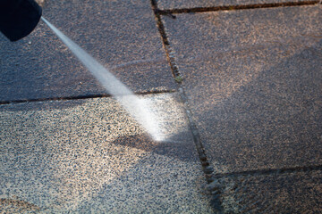 Power cleaning dirty floor, paving slabs with high pressure water jet. Cleaning with high pressure water jet. Cleaning service washing backyard and pavers with pressure water.