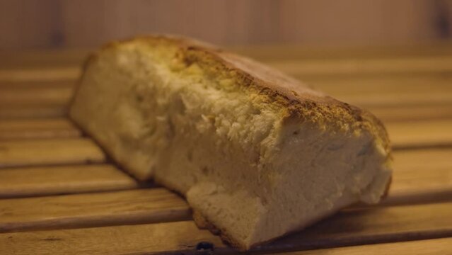 Loaf of baked bread with a thick golden crust on the shelf of the bakery, macro shot