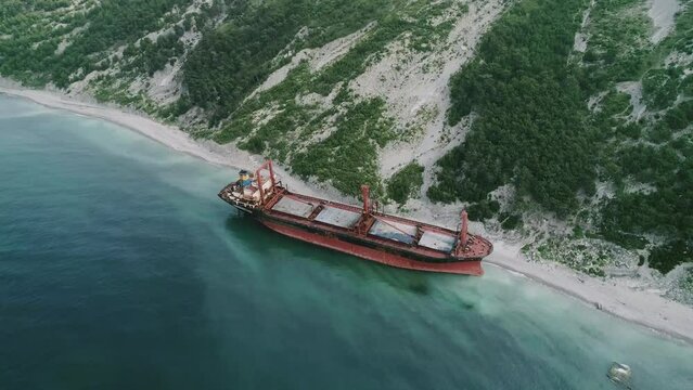 Aerial view of abandoned cargo ship. Bulk carrier ran aground after the storm. Dry cargo ship RIO stands ashore.