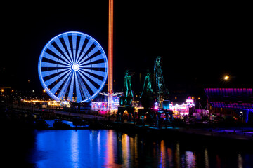 Colorful Szczecin by the river Oder at night.
City at night and neon lights, ferris wheel and...