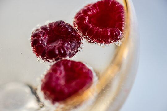 Close-Up of a glass of Champagne with fresh raspberries