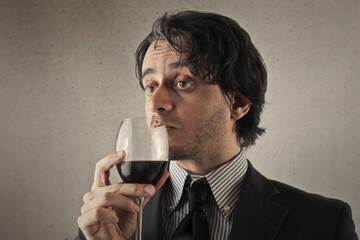 man drinks a glass of wine