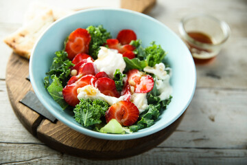 Kale salad with fresh cheese and strawberry
