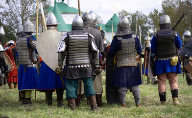 7 warriors gathered in a group before the battle. Swordsmen and spearmen in helmets, chain mail and...