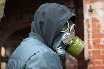 The guy in the gas mask looks over his shoulder. Photo of guy in black jacket and black hood...
