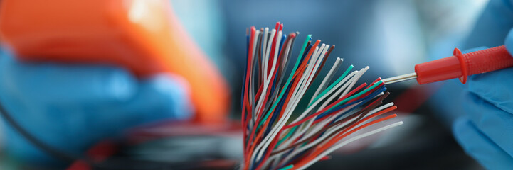 Man measuring voltage with special equipment, tool for checking pressure, bunch of wires