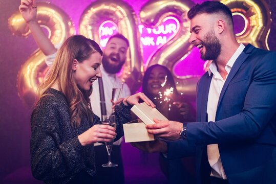 Couple exchanging gifts while on the birthday party or new years eve