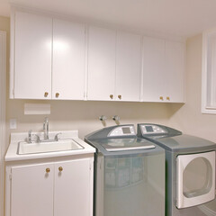 Square Interior of a laundry room with an open white door and a view of the hallway