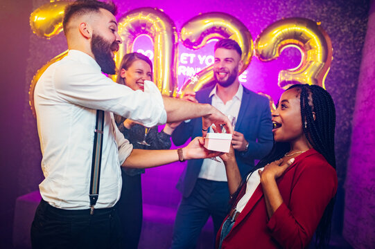 Multiracial couple exchanging gifts for birthday party or new years eve