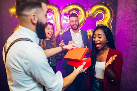 Multiracial couple exchanging gifts for birthday party or new years eve