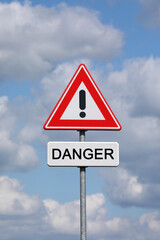 A sign with a exclamation mark warning for a dangerous situation ahead and a smaller sign below with the English word danger on it
