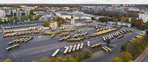 Cityscape panorama. Bird's eye perspective over half-filled bus terminus. Coaches and electrical...