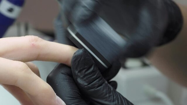File for grinding. Nail treatment with a buffer block for grinding