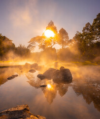 Natural hot spring with steam, rock and reflection in the morning at Chae Son National Park,...
