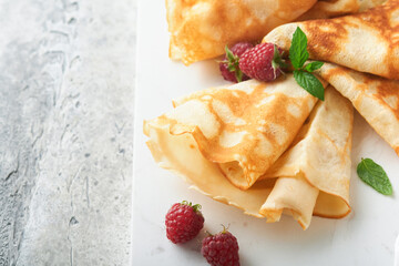 Pancakes. Stack of crepes or thin pancakes with berries, with raspberries and honey for breakfast. Pancake day is traditional american or english holiday concept. Homemade breakfast. Selective focus.