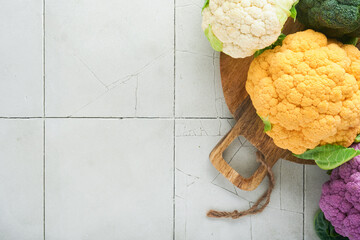 Colorful cauliflower. Various sort of cauliflower on stone tiles gray concrete background. Purple, yellow, white and green color cabbages. Broccoli and Romanesco. Agricultural harvest. Mock up.