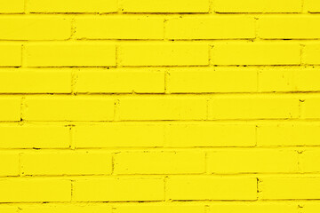Yellow paint brick wall. Abstract color home facade background. Decorative artistic urban construction. Grunge color street design texture. Bright vibrant wall pattern.
