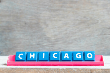 Tile alphabet letter with word chicago in red color rack on wood background