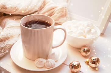  Winter, Christmas, New Year decorations composition, concept, background. White Mug, cup of tea, coffee, steam, meringue, knitted plaid. Christmas lights. Christmas mood morning. Christmas  card.