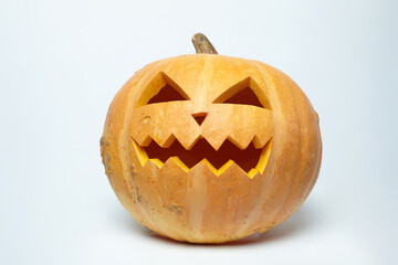 Fototapeta premium Jack's evil lantern, carved from a pumpkin with an aggressive grimace. photo on a white background