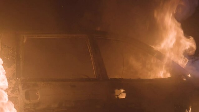 Burning car close up. Automobile on fire at night. Big flames